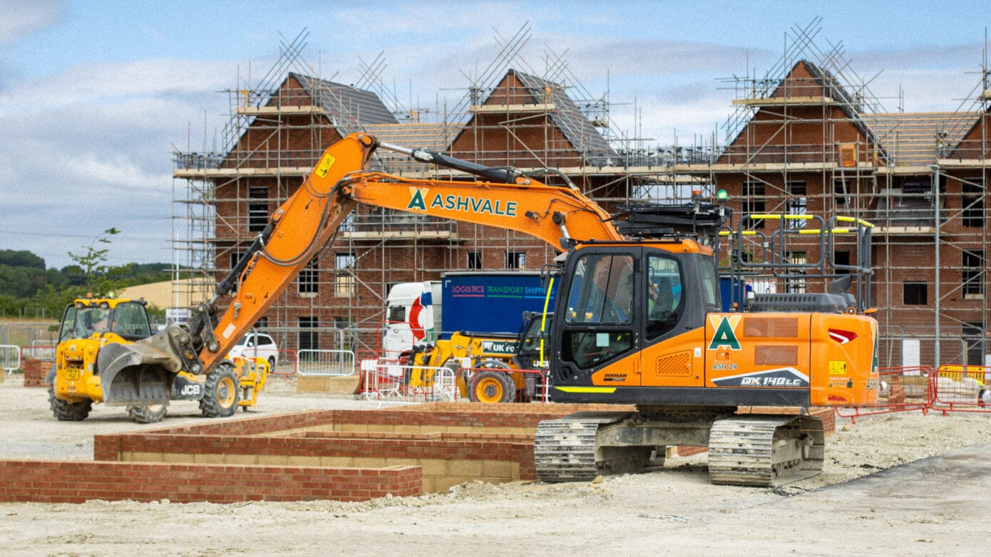 Excavators at a construction site with scaffolding.