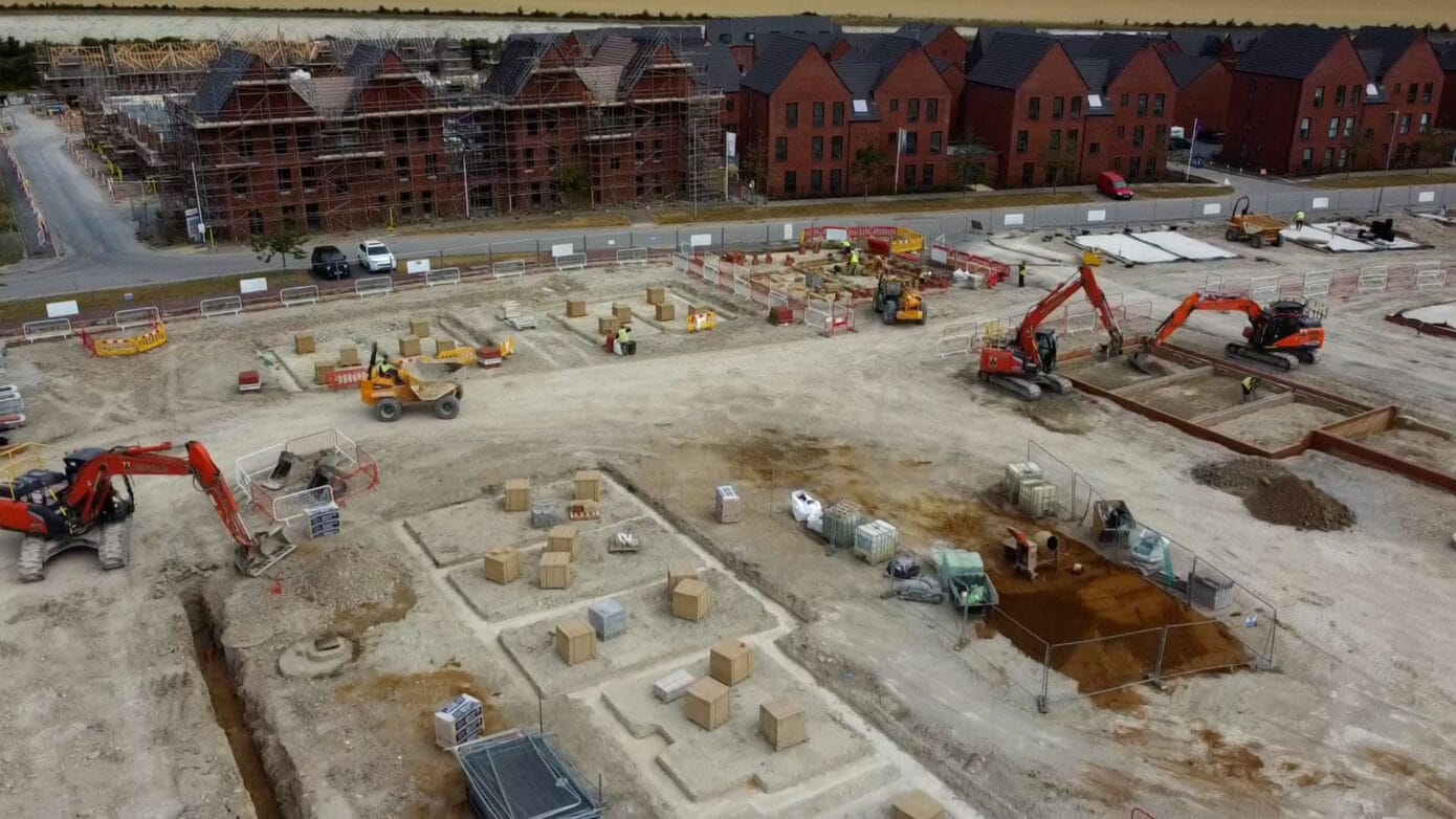 Construction site with machinery and building foundations.